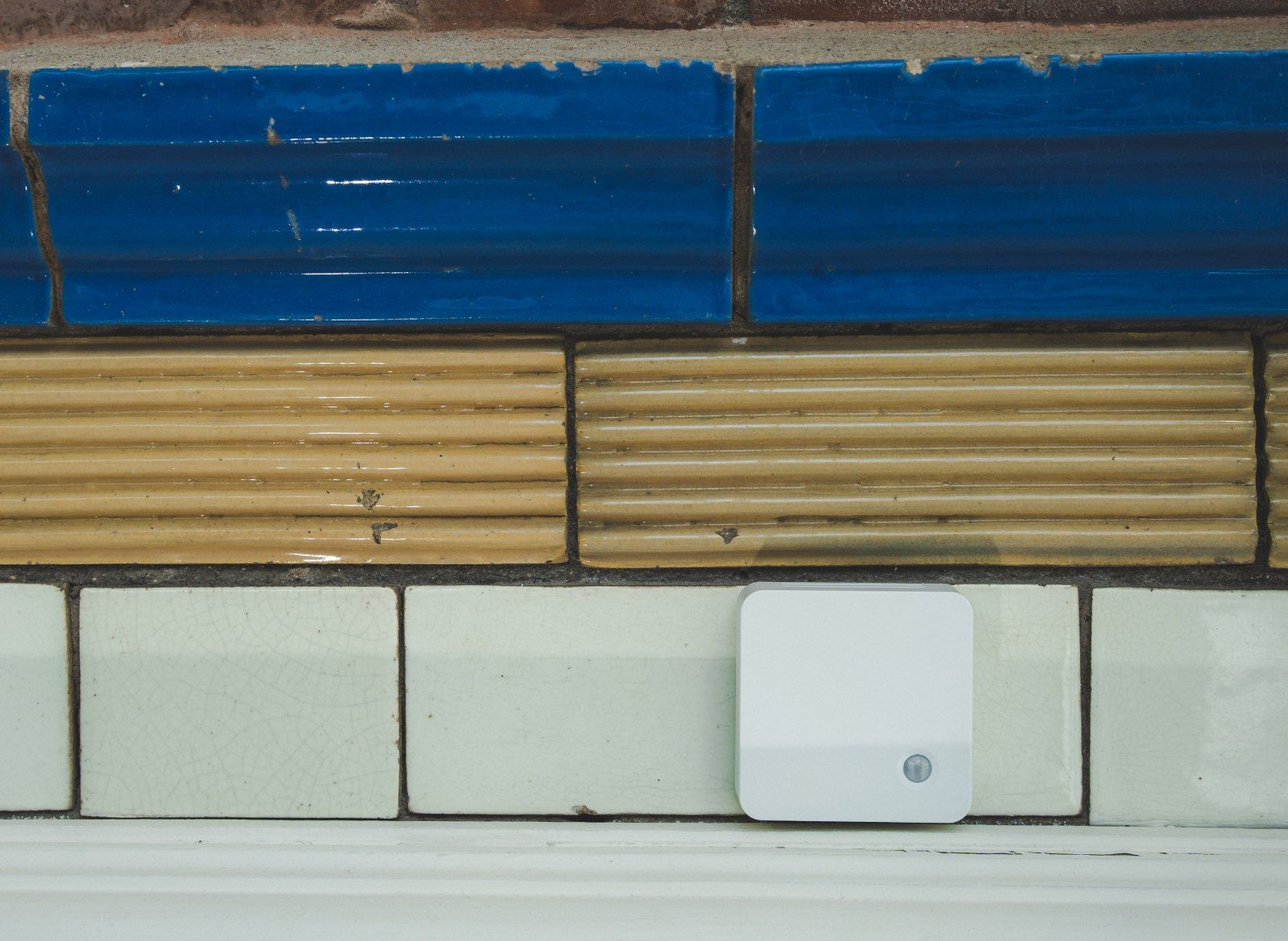 Image of the SmartWorkPlus Environment Sensor on a tiled wall
